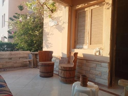 un patio con sillas de madera y una ventana en شاليه دور ارضى مدخل خاص يرى البحر en Qaryat Shurūq
