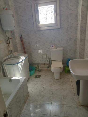 a bathroom with a toilet and a sink and a window at شاليه دور ارضى مدخل خاص يرى البحر in Qaryat Shurūq