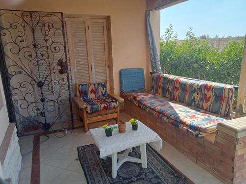 sala de estar con sofá y silla en el balcón en شاليه دور ارضى مدخل خاص يرى البحر en Qaryat Shurūq