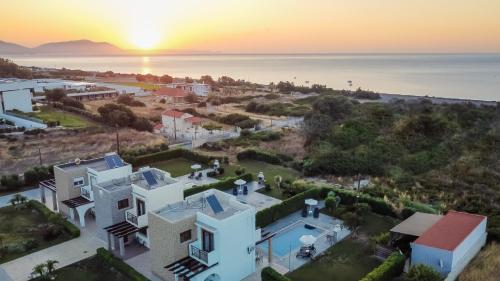 an aerial view of a house with the sunset in the background at Petra Villas in Gennadi