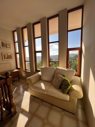 a living room with a couch in front of windows at Villa Marina B&B in Cleto