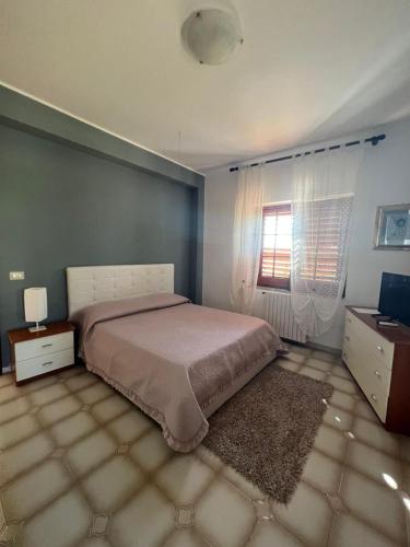 a bedroom with a large bed and a window at Villa Marina B&B in Cleto