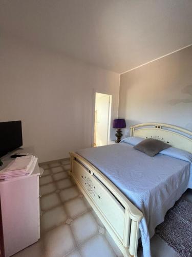 a bedroom with a large bed and a television at Villa Marina B&B in Cleto