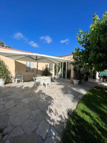 a patio with a table and an umbrella at Villa Marina B&B in Cleto