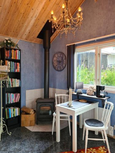 a living room with a stove and a table and chairs at Stuga i naturen in Simlångsdalen