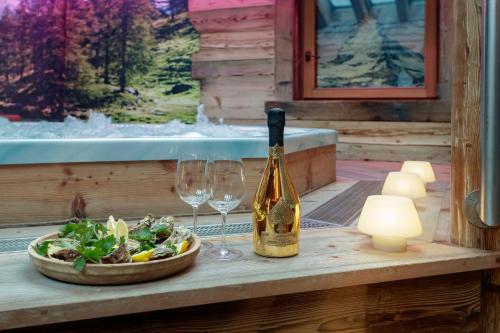 a bottle of wine next to a salad and a wine glass at Chalet Matterhorn Francois with SPA and Breakfast - 100mt lift in Breuil-Cervinia