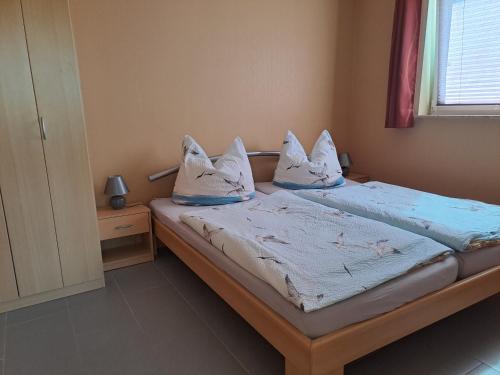 een slaapkamer met een bed met 2 kussens erop bij Ferienwohnung Riemer in Garz