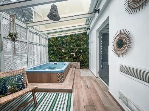 bañera de hidromasaje en un patio con ventana en La Maison Régent & spa face à la mer, en Pornichet