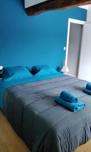 - une chambre bleue dotée d'un grand lit avec des draps bleus dans l'établissement Gîte des oliviers, à Saint-Galmier