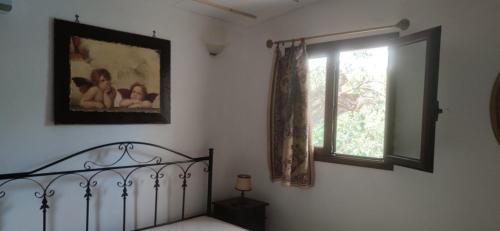 Schlafzimmer mit einem Bett und einem Fenster in der Unterkunft Casa Borea in Andrano