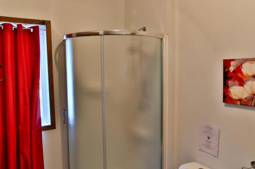 a shower in a bathroom with a red curtain at domaine de la vallee in Sainte-Rose-du-Nord