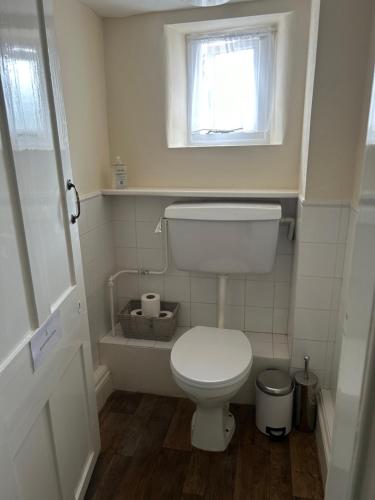 ein kleines Bad mit einem WC und einem Fenster in der Unterkunft The Lethbridge Arms in Taunton