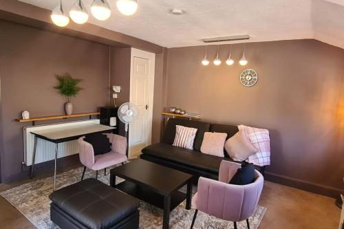 een woonkamer met een bank en een tafel en stoelen bij The Annexe in Yorkley