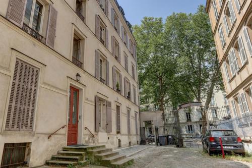 un bâtiment avec une porte rouge dans une rue dans l'établissement Le Régent - Versailles, à Versailles