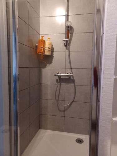 une douche avec une porte vitrée dans une salle de bain dans l'établissement Le Citadin aéroport Beauvais Paris, à Beauvais