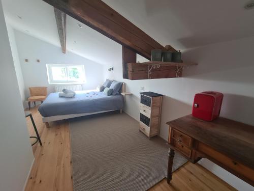 um pequeno quarto com uma cama e uma secretária em Cosy Room em Saint-Romain-Lachalm