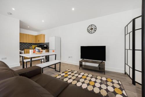 a living room with a couch and a table and a tv at London Haven at Rutland House in Ilford