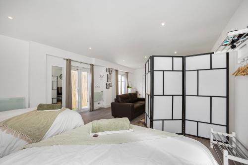 a bedroom with two beds and a living room at London Haven at Rutland House in Ilford