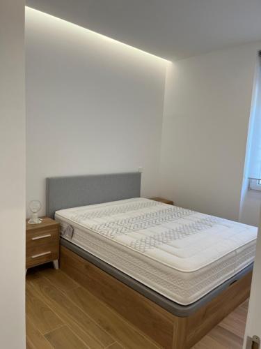 a bed in a room with a white wall at Exyca Bernabéu in Madrid