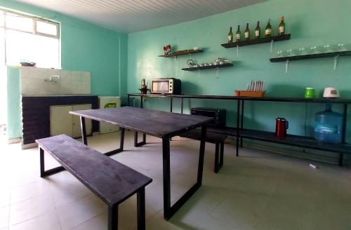 a table and a bench in a room with a kitchen at Comfy House 5 mins to Bole Airport in Addis Ababa