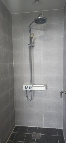 een douche met een douchekop in de badkamer bij Namhae Beach Hotel in Namhae