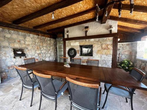 een eetkamer met een houten tafel en stoelen bij Villa Luca in Grude