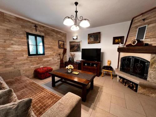 een woonkamer met een bank en een open haard bij Villa Luca in Grude