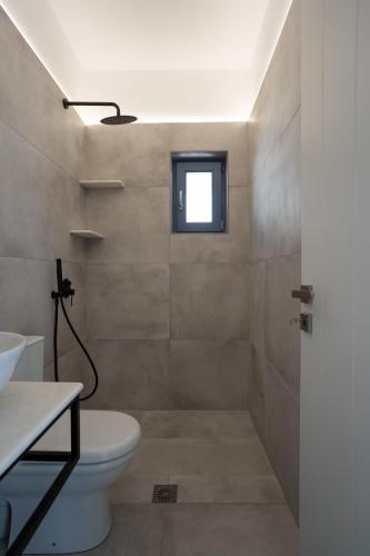 a bathroom with a shower with a toilet and a window at Traditional White House2 in Dhragoulás