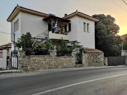 una casa al lado de una calle con una pared de ladrillo en Traditional Apartment in Volos, en Volos