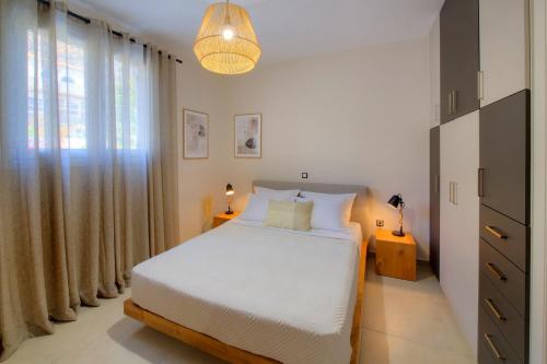 een slaapkamer met een wit bed en een groot raam bij Casa dell’ est in Monemvasia