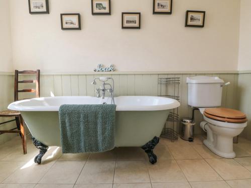 a bathroom with a bath tub and a toilet at Sawdon Heights in Sawdon