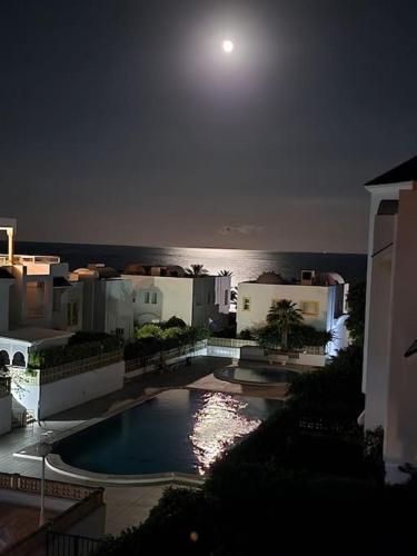 a view of a building with a pool at night at CasaSlim Hammamet in Hammamet