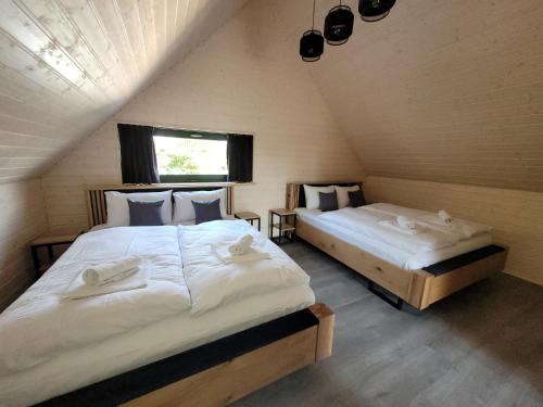 a bedroom with two beds in a attic at LoveLake dom z jacuzzi in Radzyń