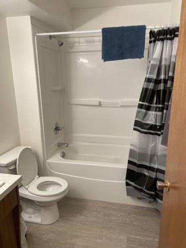 a white bathroom with a toilet and a shower at Stunning 1 Bedroom Apartment in Camrose