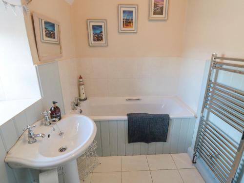 a bathroom with a sink and a bath tub at Chapel Cottage in Ebberston