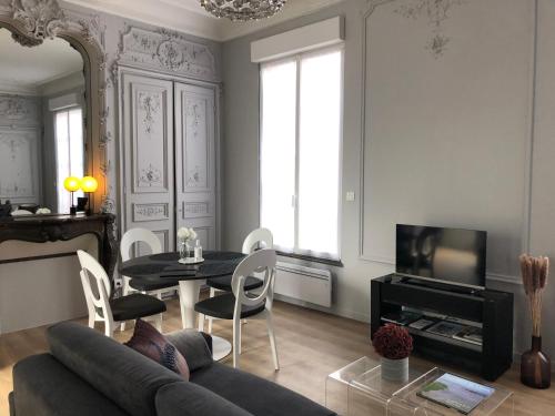 salon z kanapą i stołem w obiekcie Maison Gabriel Appartement PLUME w mieście Abbeville