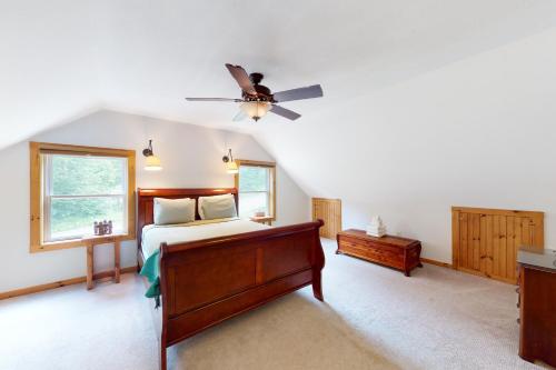 - une chambre avec un lit et un ventilateur de plafond dans l'établissement Shallow Brook, à Jay
