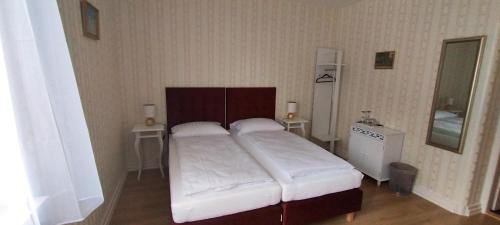 a bedroom with a large bed with white sheets at Liahof in Ullared