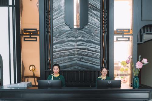 two women sitting at a desk with their laptops at Goldient Boutique Hotel in Da Lat