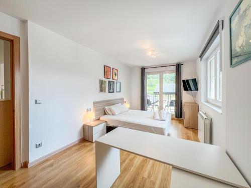 a white room with two beds and a tv at Barthe Holidays I Apartamento con encanto en Arinsal 6PAX a pie de pistas I Balcón con vistas y parking I Milu in Arinsal