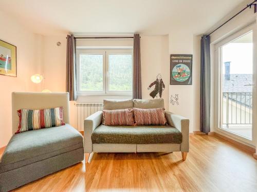 a living room with a couch and a chair at Barthe Holidays I Apartamento con encanto en Arinsal 6PAX a pie de pistas I Balcón con vistas y parking I Milu in Arinsal