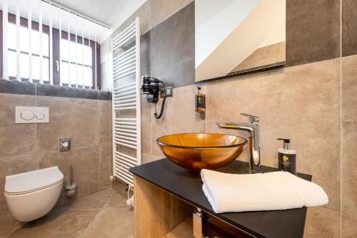 a bathroom with a bowl sink and a toilet at Penzion Golden Crown in Český Krumlov