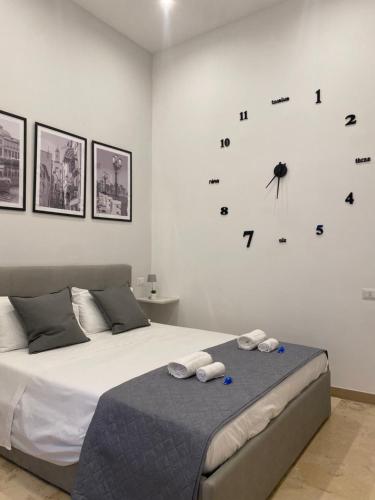 een slaapkamer met een bed met een klok aan de muur bij Del Carmine 23 in Bari