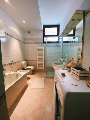 a bathroom with a tub and a toilet and a sink at Fonzi’s House in La Spezia
