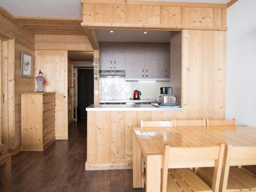 une cuisine avec des armoires en bois et une table en bois dans l'établissement 2 pièces luxe avec balcon et Wifi à 500m des pistes - FR-1-449-44, à Tignes