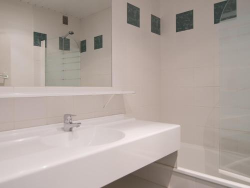 une salle de bain blanche avec un lavabo et un miroir dans l'établissement Studio cosy Sud/Ouest, proche pistes, Wifi, animaux ok - FR-1-449-130, à Tignes