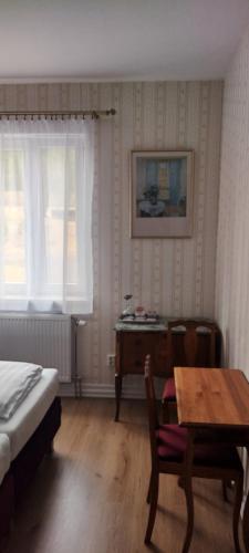 a bedroom with a bed and a table and a desk at Liahof in Ullared