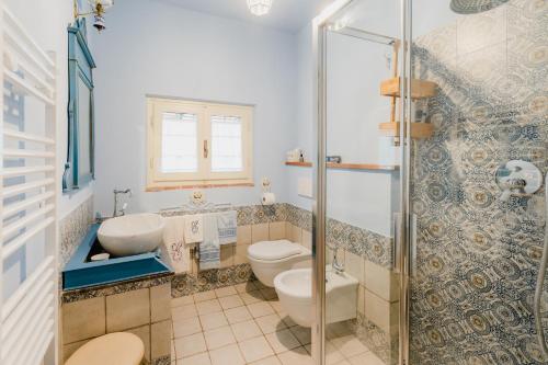 łazienka z 2 toaletami, umywalką i prysznicem w obiekcie la tana del geco w mieście Massarosa