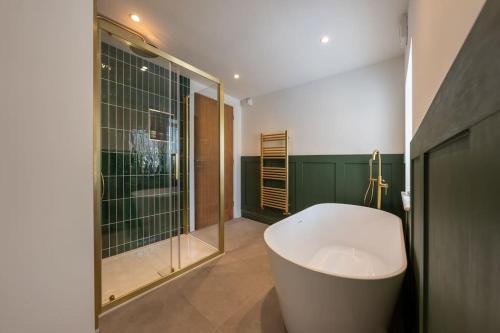 a bathroom with a bath tub and a shower at Stylish, comfortable, convenient! in Bala