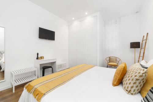 a white bedroom with a bed and a fireplace at LUMO Flat Fátima in Fátima